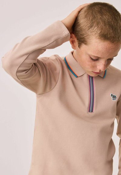 Helles beige Langarm-Polo mit einem Reißverschluss und einem mehrfarbigen gestreiften Kragen. Mit einem kleinen gestickten Tierlogo auf der Brust.