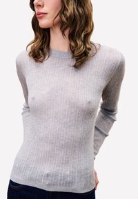 Pull gris clair côtelé à manches longues et col rond, présentant un motif tricoté texturé et une coupe ajustée.
