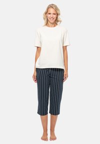 Biały t-shirt z krótkim rękawem i granatowe, prążkowane spodnie 3/4. Miękki materiał z luźnym krojem; pionowe prążki na spodniach dodają szczegółu.