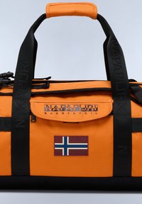 Oranžová sportovní taška s černými akcenty, s výrazným logo a nášivkou norské vlajky. Pevné rukojeti a nastavitelný popruh jsou součástí.