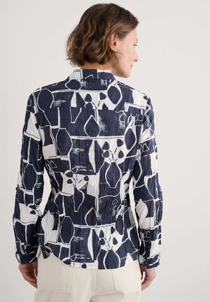 Camicia a maniche lunghe blu navy e bianca con motivi a forme astratte, tessuto leggero, superficie strutturata e colletto con bottoni.