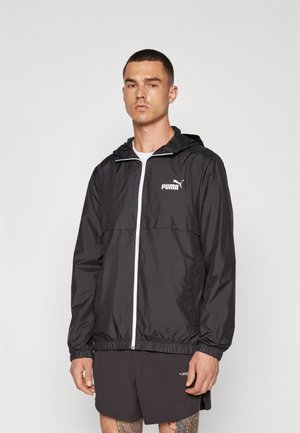 Giacca a vento nera con zip frontale, cappuccio regolabile, polsini elasticizzati e logo PUMA bianco sul petto. Materiale liscio e leggero.