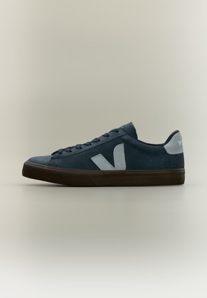 Baskets basses bleu foncé avec semelle noire, logo blanc "V" sur le côté et languette de talon blanche avec marquage, présentées de profil sur fond neutre.