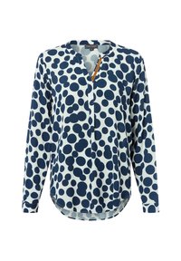 Blusa a maniche lunghe in tessuto azzurro chiaro con pois blu navy, scollatura a V e orlo arrotondato con dettaglio di bottone.