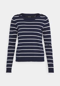 Pull en stripe bleu marine à manches longues, avec des rayures blanches horizontales et des accents de boutons dorés sur l'épaule. Texture de tissu douce.