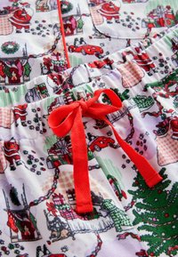 Pajama kratke hlače z božično tematiko iz mehkega blaga. Imajo barvit tisk s svetnikom Miklavžem, darili in okraski ter rdečo vrvico in elastičen pas.