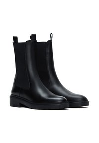Stivaletti neri in pelle con pannelli laterali elastici e linguette; superficie liscia, suola in gomma spessa e design pulito e minimalista.