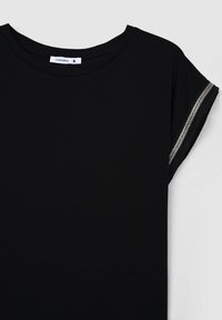 T-shirt nera realizzata in morbido tessuto, con scollatura rotonda e maniche corte, dotata di un accento metallico sui bordi delle maniche.