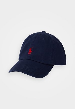 Sötétkék baseballsapka, pamutból készült, ívelt karimával. Elöl piros hímzett logóval és hat szellőzőlyukkal rendelkezik a tetején.