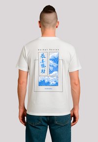 Weißes Baumwoll-T-Shirt mit einem blauen Wellenmotiv auf der Rückseite, umrahmt von schwarzen Linien und dem Text "Shibui Series" und "FANTASTIC."