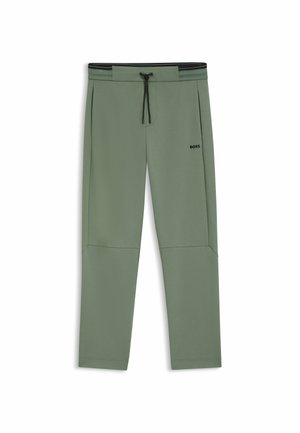 Pantalons de survêtement verts en tissu doux, dotés d'une taille élastique avec cordon de serrage, de poches latérales et d'un discret logo sur la cuisse.