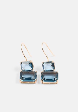 Gouden oorbellen met twee rechthoekige blauwe edelstenen, één grotere onderaan en een kleinere bovenaan, met een gladde gepolijste afwerking.