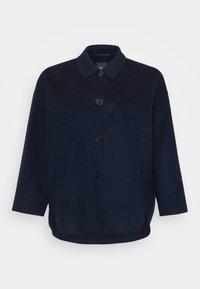 Námořnická modrá oversized vlněná bunda s límcem, čtyřmi černými knoflíky na přední straně a dlouhými rukávy, vystavená na bílém pozadí.
