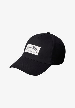 Μαύρο καπέλο μπέιζμπολ με καμπύλη γείσο και λευκή ετικέτα στην μπροστινή πλευρά με το κείμενο "Calvin Klein New York City".