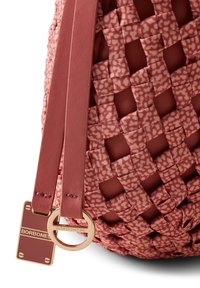 Gewebte Tasche in staubigem Rosenholz mit einem glänzenden goldenen Markenanhänger. Verfügt über ein strukturiertes Muster und glatte Lederträger. Runde, strukturierte Form.