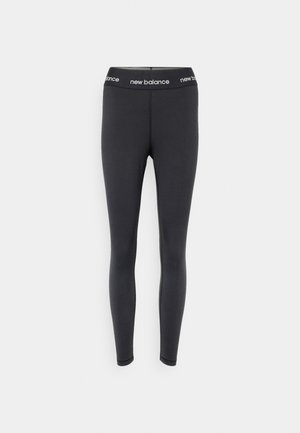 Leggings negros hechos de tela elástica, con una cinturilla ancha que presenta la marca "new balance", con una textura suave y un diseño ajustado.