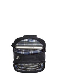 Schwarzer Rucksack mit offenem Hauptfach, das das Innere aus kariertem Stoff und einen silbernen Laptop in einer gepolsterten Hülle zeigt.