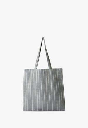 Szara torba na ramię z białymi pionowymi paskami, wykonana z miękkiego materiału. Posiada dwie długie rączki oraz obszerne prostokątne wnętrze.