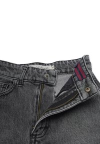 Grå denimjeans med dragkedja, midjeband med knapp och präglad etikett. Har en röd och blå randig detalj nära knäppningen.