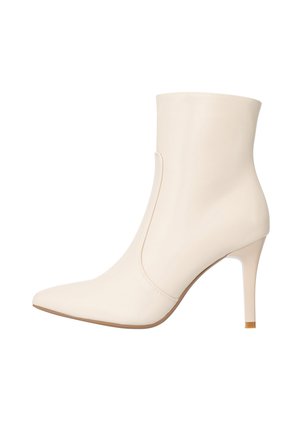 Stivale alla caviglia con punta a spillo in pelle crema, design aderente, tacco a stiletto alto e ritagli laterali per un dettaglio aggiuntivo.