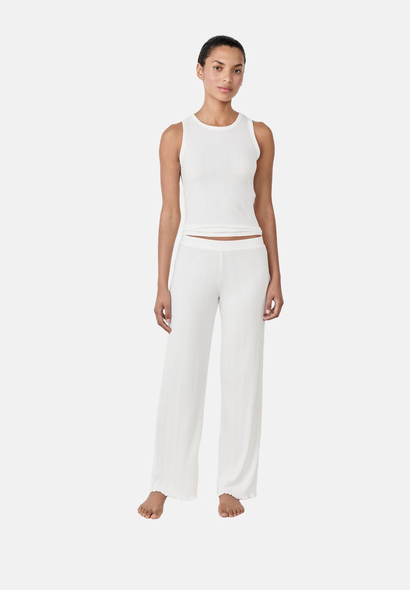 Conjunto de top de tirantes blanco acanalado y pantalones de pierna ancha, con un ajuste relajado y textura suave. Sin patrones visibles ni detalles metálicos.