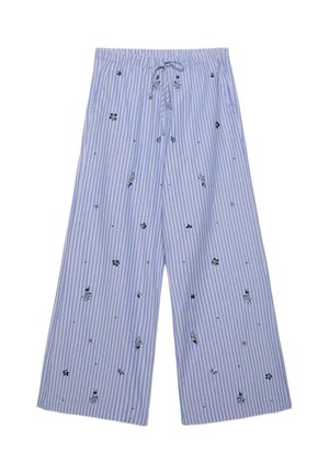 Pantalon à jambes larges rayé vertical bleu et blanc avec petits motifs floraux noirs et blancs et taille à cordon.