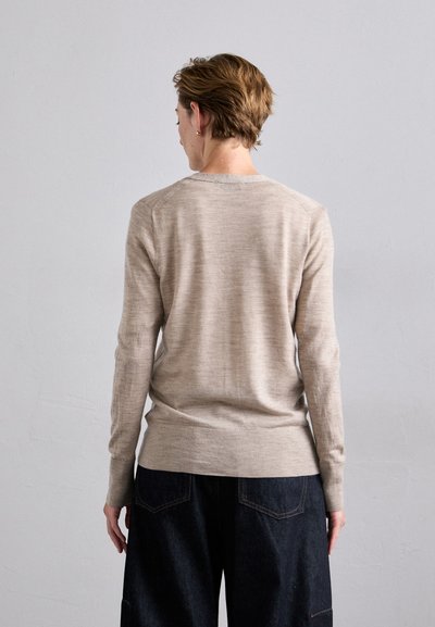 Helles beige Langarmpullover mit Rundhalsausschnitt. Weicher Stoff, minimalistisches Design und dezente Rippdetails an den Ärmeln und am Saum.