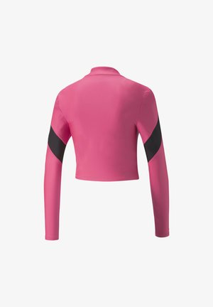 Ružičasti dugi rukav krojeni top s visokim ovratnikom, koji ima crne naglašene pruge na rukavima. Napravljen je od glatkog, laganog materijala.