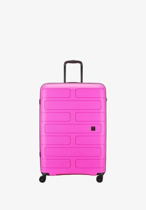 Valigia rigida di un vivace colore rosa, con scanalature orizzontali, una maniglia retrattile e quattro ruote nere per la mobilità.