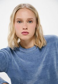 Lichtblauw, geribbelde gebreide trui met een ronde halslijn en lange mouwen. Zachte textuur, subtiele glans, casual pasvorm en geen zichtbare patronen.