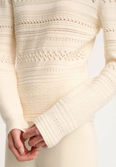 Strickpullover in Creme mit komplizierten Mustern und offenen Maschen, mit gerippten, übergroßen Ärmeln und einem strukturierten Körper.