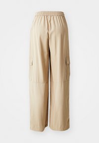 Beige cargobyxor med elastisk midja, två sidofickor, löst skräddade och en slät tygstruktur.