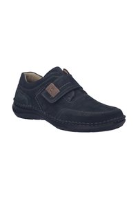 Scarpa in suede nera con un cinturino in Velcro, cuciture a contrasto e punta rotonda. Fodera morbida e suola in gomma per il comfort.