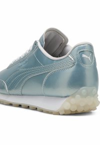 Baskets en cuir bleu clair avec des accents blancs, une panneau latéral texturé, et une semelle en caoutchouc blanche avec des motifs circulaires pour l'adhérence.