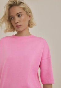 Roze t-shirt met korte mouwen en een ronde halslijn, gemaakt van een zachte katoenmix, met een relaxte pasvorm en minimale stikdetails.