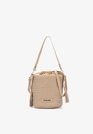 Bolso tipo cubo beige con textura tejida, dos borlas, correa ajustable para el hombro y cierre con cordón.