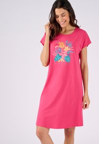Abito da notte in cotone rosa con un design grafico floreale dai colori vivaci e il testo "NOTTE TROPICALE" sotto l'illustrazione. Maniche corte.
