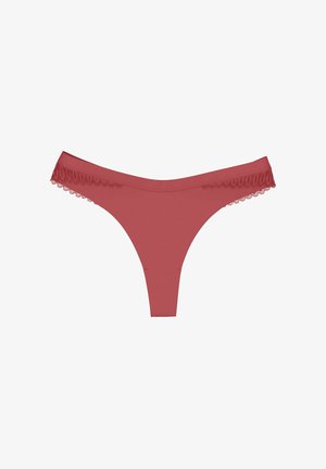 String rouge en microfibre avec une texture lisse, ornée d'une délicate bordure en dentelle le long de la taille. Design minimaliste avec une forme en V.