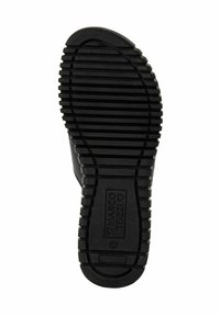 Suola di scarpa in gomma nera con scanalature orizzontali per aderenza, punta arrotondata e logo impresso sul lato inferiore.