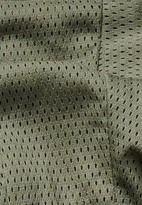 Light olive green textured fabric with small rectangular perforations and visible stitching details.