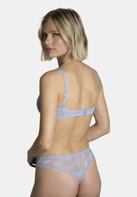 Soutien-gorge en dentelle bleu clair et string assorti, présentant des motifs géométriques, des bretelles réglables et une fermeture à crochets au dos.