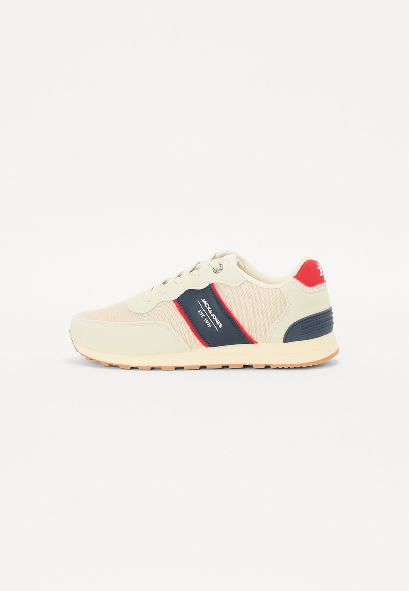 Beige sneakers med marineblå og røde detaljer, overdel i mesh og stoff, rund tå og kontrasterende gummisåle for grep og holdbarhet.