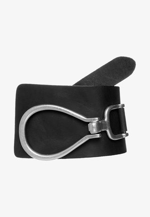 Ceinture en cuir noir avec une grande boucle argentée en forme de larme et une boucle à ardillon métallique standard, roulée sur un fond blanc.