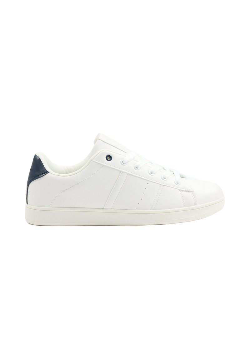 Zapatillas blancas con parte superior de cuero suave, talón en contraste de azul marino oscuro, punta redonda y diseño de cordones con seis ojales. Suela plana de goma clásica.
