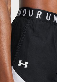 Black athletic shorts with a wide black waistband featuring white "ARMOUR" text. Includes a white Under Armour logo on the side.