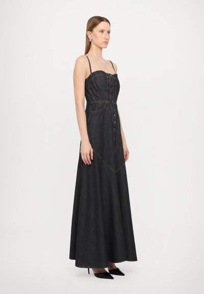 Maxi sukienka dżinsowa w ciemnoniebieskim kolorze z cienkimi ramiączkami, zapięciem na guziki z przodu i rozkloszowanym dołem. Posiada kontrastowe przeszycia oraz dopasowaną górę.