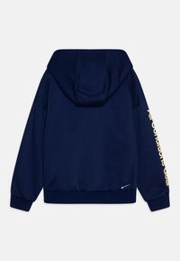 Sweatshirt azul-marinho com capuz ajustável, punhos e barra com nervuras. Apresenta texto amarelo ao longo da manga e um pequeno logótipo perto da barra.
