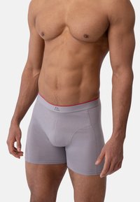 Harmaat bokserialushousut, istuva malli, joustava vyötärönauha, jossa punainen korostus, ja pehmeä, kevyt kangas. Vähäiset ompelusaumat.