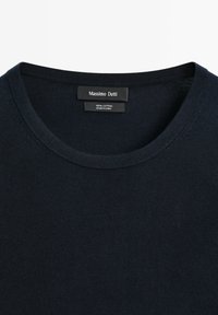 Navy blue cotton crew-neck sweater with ribbed texture and tag detailing. Made in China.