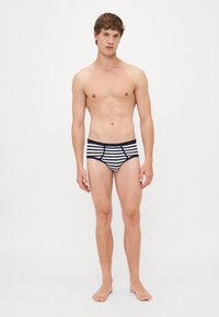 Gestreifte Badeslips in Marineblau und Weiß, mit einem figurnahen Design und einem kontrastierenden Bund. Glattes Material mit einer weichen Textur.
